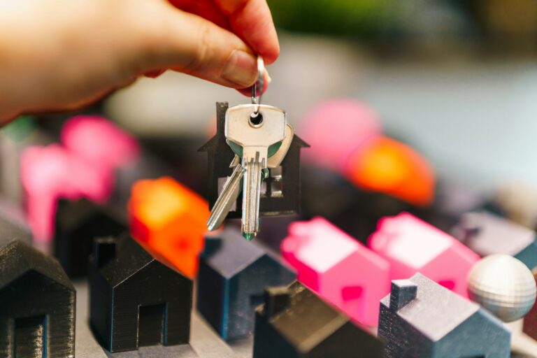 House keys held over model houses
